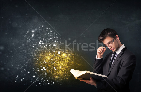 Młodych facet czytania magiczny książki tablicy Zdjęcia stock © ra2studio