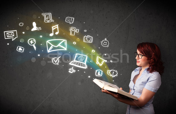 Stock photo: Young woman reading a book with multimedia icons coming out of t