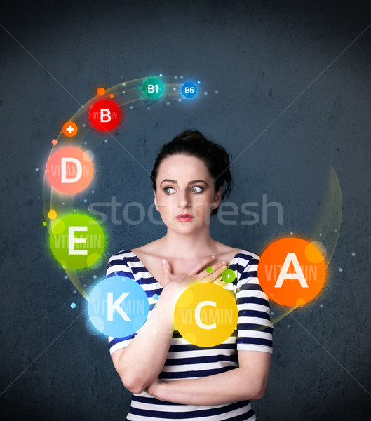 Young woman thinking with vitamins circulation around her head Stock photo © ra2studio