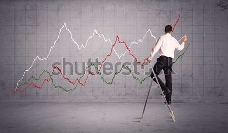 Stock photo: male on ladder drawing chart lines