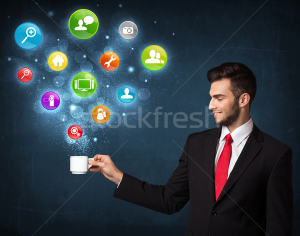 Businessman holding a white cup with setting icons Stock photo © ra2studio