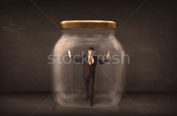 Stock photo: Businessman shut into a glass jar concept