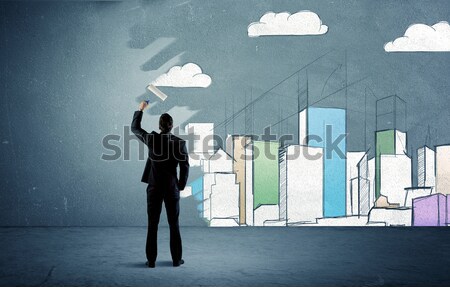 Salesman painting tall buildings on urban wall Stock photo © ra2studio