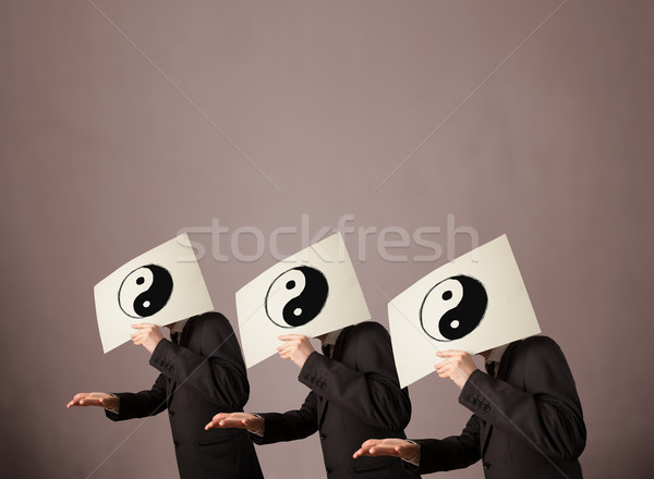 Handsome people in formal gesturing with yin yang sign on cardbo Stock photo © ra2studio