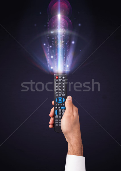 Hand with remote control and shining numbers Stock photo © ra2studio