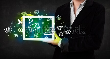 Person holding a tablet with media icons and symbols Stock photo © ra2studio