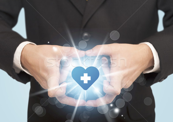 Stock photo: Hands creating a form with heart blue cross