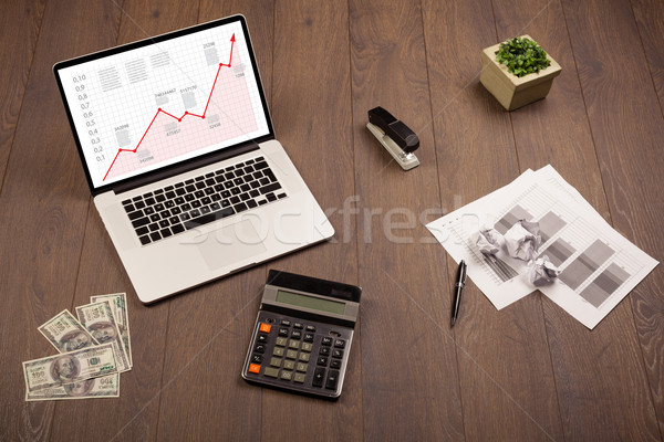 Computer desk with laptop and red arrow chart in screen Stock photo © ra2studio