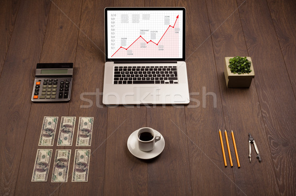 Computer desk with laptop and red arrow chart in screen Stock photo © ra2studio