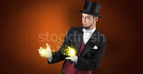 Illusionist holding superpower on his hand Stock photo © ra2studio