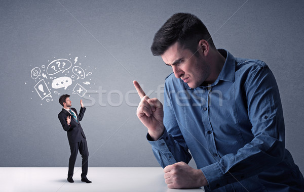 Young businessman fighting with miniature businessman Stock photo © ra2studio