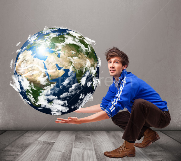 Good-looking man holding 3d planet earth Stock photo © ra2studio