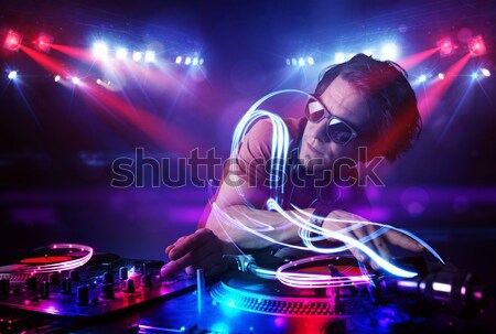 Disc jockey playing music with electro light effects and lights Stock photo © ra2studio