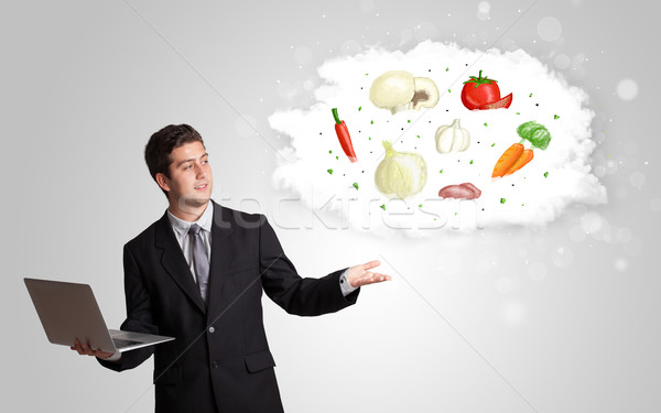 Handsome man presenting a cloud of healthy nutritional vegetable Stock photo © ra2studio