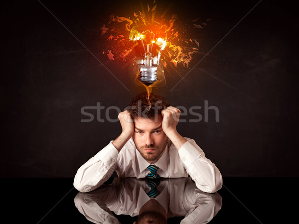 Businessman sitting under a blowing idea bulb Stock photo © ra2studio