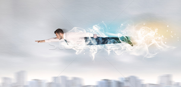Hero superman flying above city with smoke left behind Stock photo © ra2studio