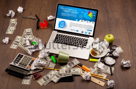 Computer desk with laptop and red arrow chart in screen Stock photo © ra2studio