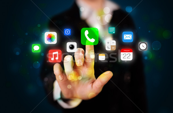 Young businesswoman pressing colorful mobile app icons with boke Stock photo © ra2studio