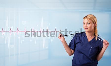 Pretty medical doktor listening to red pulse and heart rates Stock photo © ra2studio