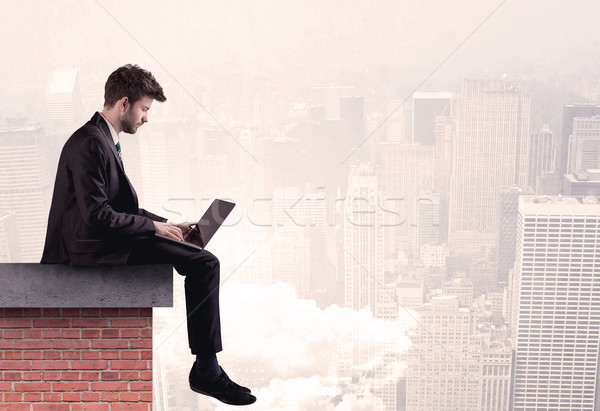 Office worker sitting on rooftop in city Stock photo © ra2studio