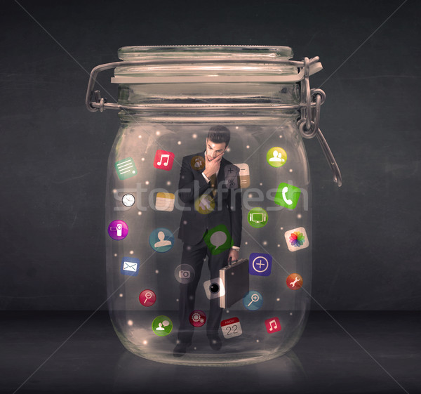 Businessman captured in a glass jar with colourful app icons con Stock photo © ra2studio