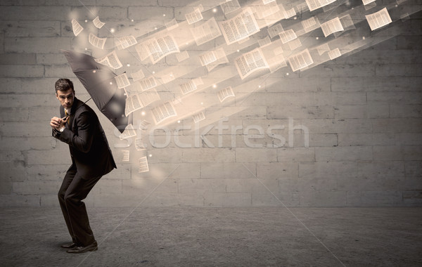 Business man protecting with umbrella against wind of papers Stock photo © ra2studio