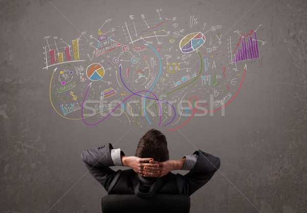 Young business man looking at sketches of graphs and symbols Stock photo © ra2studio