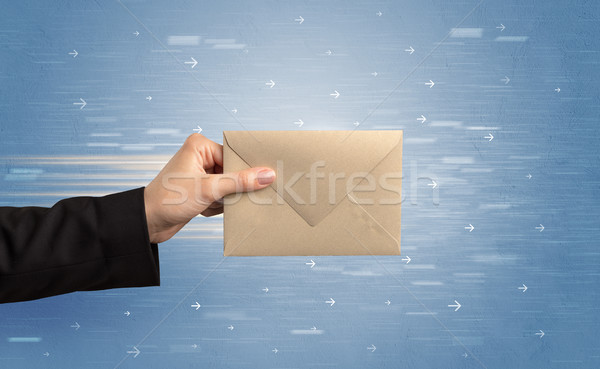 Hand holding envelope with arrows around Stock photo © ra2studio