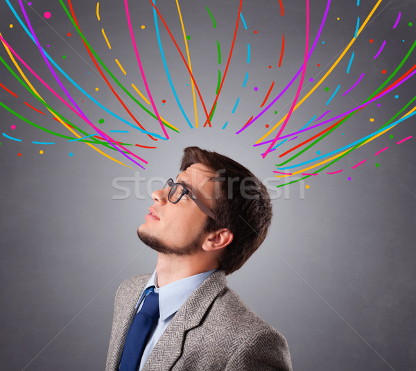 Young man thinking wiht colorful abstract lines overhead Stock photo © ra2studio