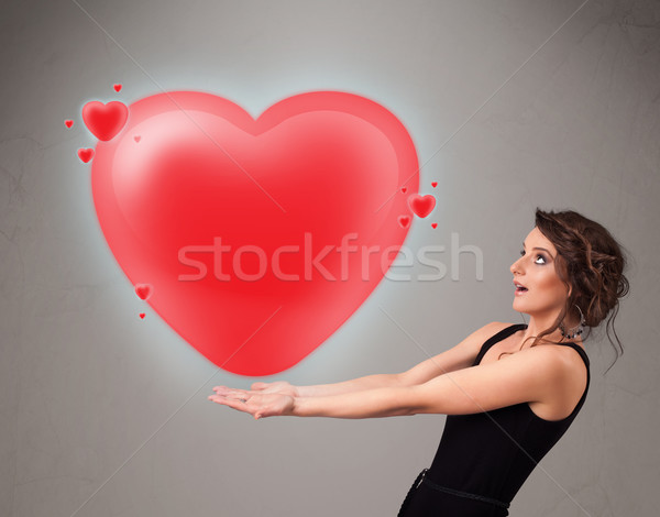 Young lady holding lovely 3d red heart Stock photo © ra2studio