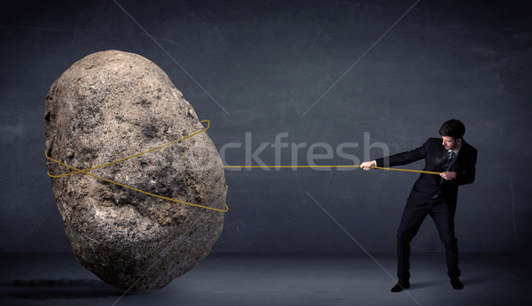 Businessman pulling huge rock with a rope  Stock photo © ra2studio