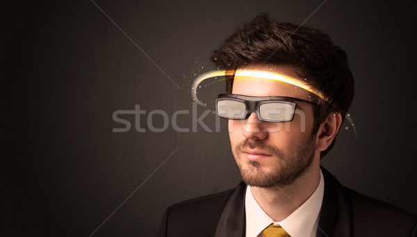 Stock photo: Handsome man looking with futuristic high tech glasses 