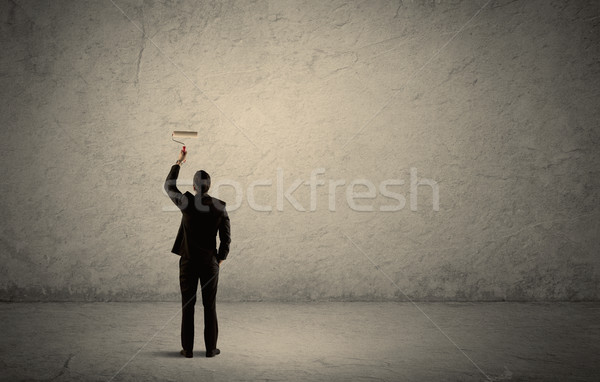 Salesman with roller standing at empty wall Stock photo © ra2studio