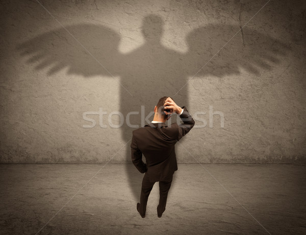 Honest salesman with angel shadow concept Stock photo © ra2studio