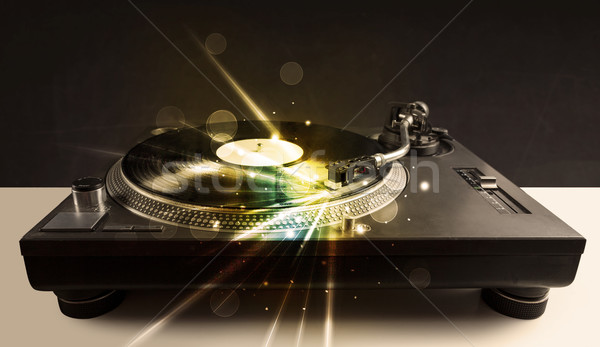 Stock photo: Music player playing vinyl with glow lines comming from the need