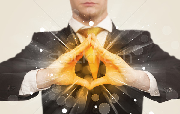 Stock photo: Hands creating a form with yellow shines