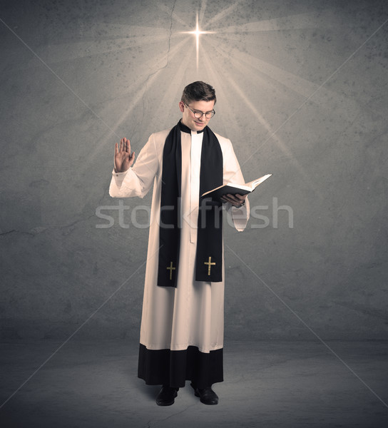 Stock photo: young priest in giving his blessing