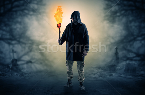 Man coming out from a thicket with burning flambeau Stock photo © ra2studio