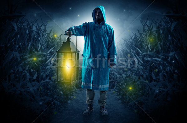 Hombre fuera linterna impermeable noche mirando Foto stock © ra2studio