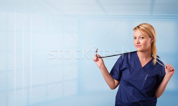 Pretty young nurse in hospital listening to empty copy space with sthetoscope Stock photo © ra2studio