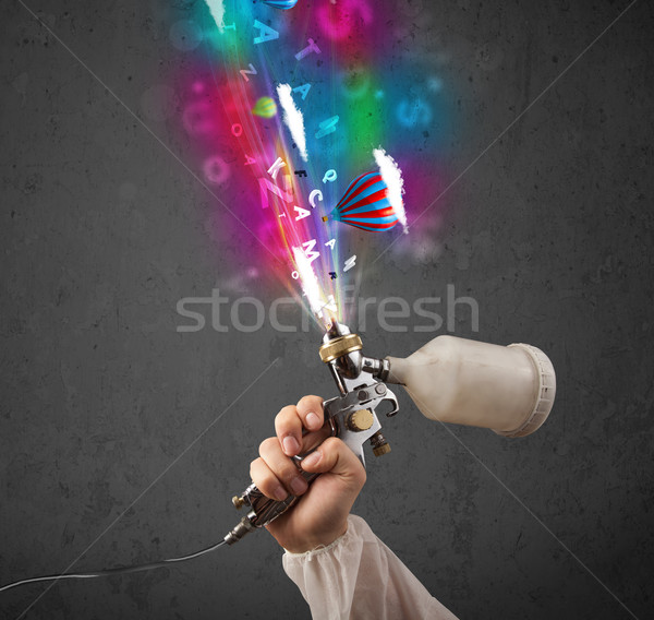 Worker with airbrush and colorful abstract clouds and balloons Stock photo © ra2studio