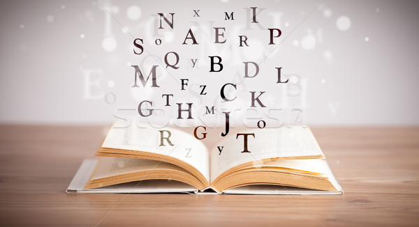 Stock photo: Opened book with flying letters