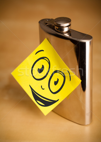 Post-it note with smiley face sticked on hip flask Stock photo © ra2studio