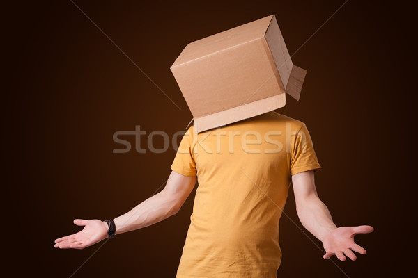 Young man gesturing with a cardboard box on his head Stock photo © ra2studio