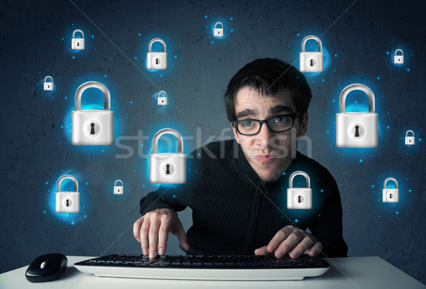 Young hacker with virtual lock symbols and icons Stock photo © ra2studio