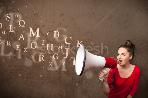 Young girl shouting into megaphone and text come out Stock photo © ra2studio