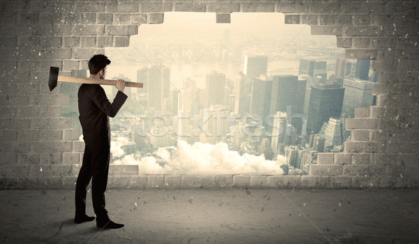 Business man hitting wall with hammer on city view Stock photo © ra2studio