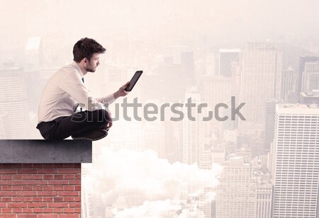 Office worker sitting on rooftop in city Stock photo © ra2studio