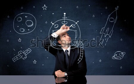 Sales person drawing helmet and space rocket Stock photo © ra2studio