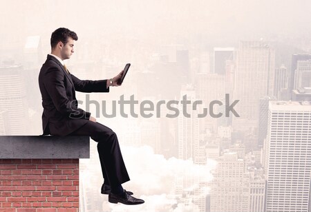 Office worker sitting on rooftop in city Stock photo © ra2studio